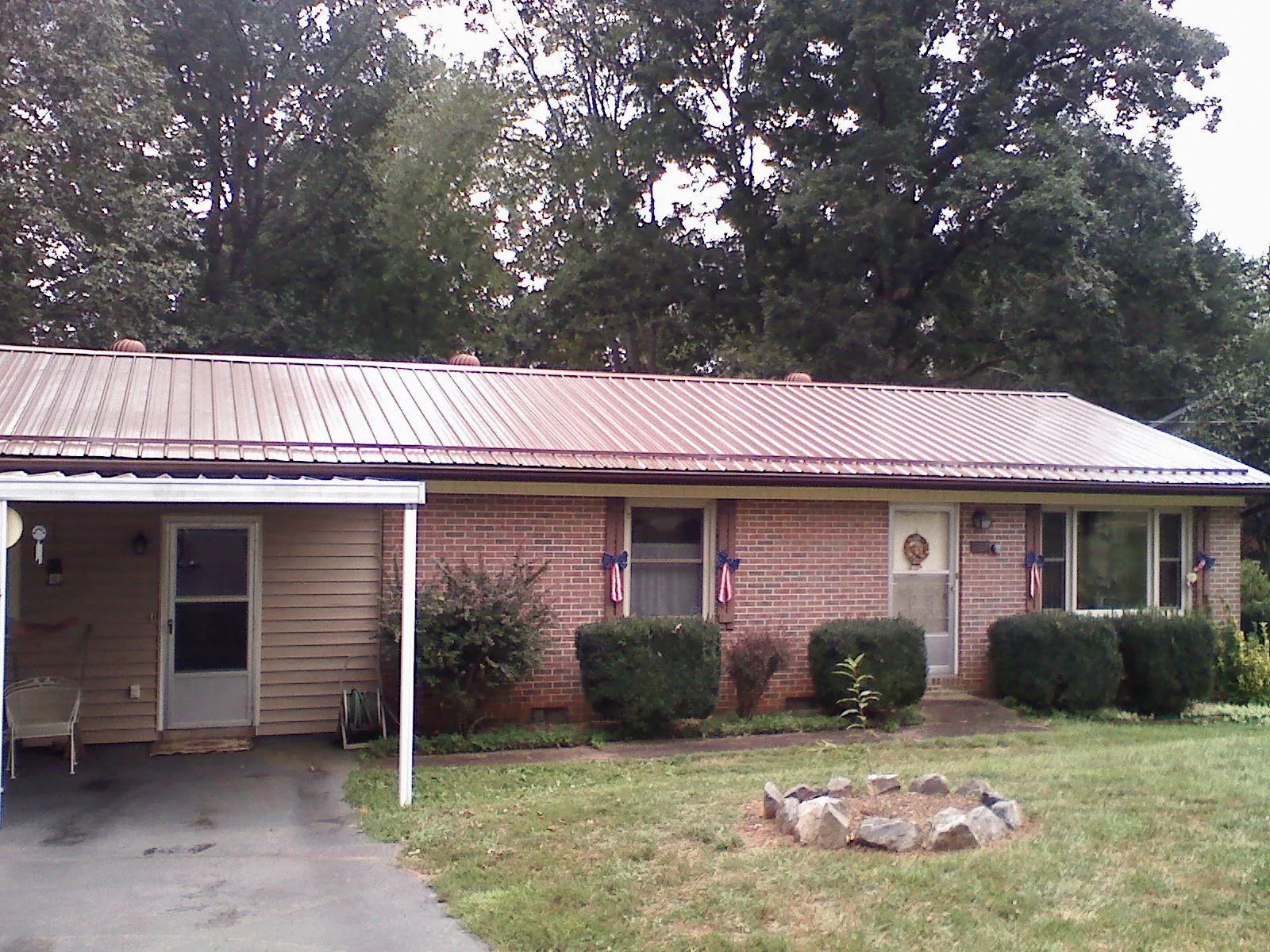 Bronze metal roof and carport on a brick ranch home — Roof Repair work by our crew in Trenton